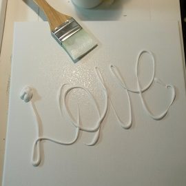 canvas with gesso spelling out LOVE Because everything begins with love